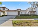 Charming single-story home with a well-maintained lawn and a red tile roof at 16613 Caribbean Breeze Way # 34714, Clermont, FL 34714
