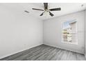 Bright bedroom features wood floors, a ceiling fan, and a large window for ample natural light at 16817 Gold Star Ct, Clermont, FL 34714