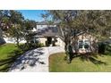 Charming home featuring solar panels and a long driveway surrounded by lush landscaping and mature trees at 2005 Blackbird Dr, Apopka, FL 32703