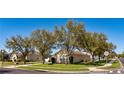 Street view of a cozy home with a well-maintained lawn and mature trees providing shade at 2005 Blackbird Dr, Apopka, FL 32703