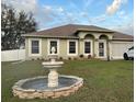 Inviting single-story home featuring a stone fountain and well-maintained landscaping with a newer car parked in the driveway at 203 Flounder Pl, Kissimmee, FL 34759