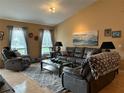 Warm living room showcasing a plush leather sofa, recliner chairs, and a soft, neutral-toned rug at 203 Flounder Pl, Kissimmee, FL 34759