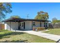 View of the house with a covered carport and a neatly landscaped walkway to the front door at 212 Oakland Ave, Sanford, FL 32773