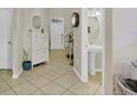 Open entryway with tile floors, leading to a powder room, and a staircase in the background at 3320 Grande Heron Dr, Harmony, FL 34773