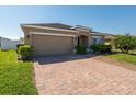Well-maintained home with a two-car garage, brick driveway, and manicured landscaping at 3797 Briarwood Estates Cir, St Cloud, FL 34772