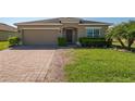 Charming single-story home featuring a well-manicured lawn, brick driveway, and cozy front entrance at 3797 Briarwood Estates Cir, St Cloud, FL 34772