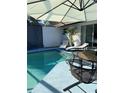 Exterior view of the screened-in pool, with lounge chairs, a bistro table, and access to the house at 4938 Samoa Cir # 6, Orlando, FL 32808