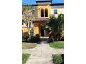 Inviting building entrance featuring a covered doorway with tile roof and lush landscaping at 5479 Vineland Rd # 9104, Orlando, FL 32811