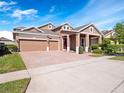 Beautiful two-story house with a three car garage, brick driveway, well kept lawn, and attractive landscaping at 6232 Talaria Dr, Windermere, FL 34786