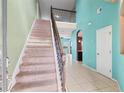 Bright foyer features tile flooring, staircase with carpet and iron railing, open concept, and ample natural light at 625 Silverthorn Pl, Groveland, FL 34736