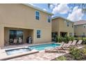 Inviting backyard features a sparkling pool, a jacuzzi, lounge chairs, and an outdoor dining area at 7568 Marker Ave, Kissimmee, FL 34747