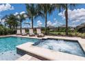 Relaxing backyard oasis showcasing a refreshing pool, an attached spa, and comfortable lounge chairs at 7568 Marker Ave, Kissimmee, FL 34747