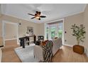 Bright living room with wood flooring, a ceiling fan, and large doors opening to the outside area at 911 N Orange Ave # 104, Orlando, FL 32801