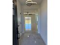 Bright and airy foyer with glossy tiled floors and modern light fixture at 917 Swallow St, Deltona, FL 32725