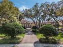 Beautiful home with a circular driveway, pillars at the front door, and lush landscaping beneath a gorgeous tree canopy at 10411 Hart Branch Cir, Orlando, FL 32832