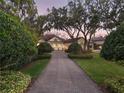 An expansive home with a circular driveway and lush landscaping is framed by beautiful, mature trees at 10411 Hart Branch Cir, Orlando, FL 32832