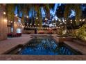 Gorgeous backyard featuring a sparkling pool, lush tropical landscaping, string lights, and cozy seating areas at 1500 Whitstable Ct, Lake Mary, FL 32746