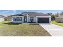 Charming single-story home showcasing a well-manicured lawn and a modern exterior design with a two-car garage at 15499 Sw 48Th Ave, Ocala, FL 34473