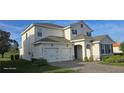Elegant home featuring a stucco facade, gray shutters, a two-car garage, and an inviting front entrance at 18410 Blue Heron Cir, Deer Island, FL 32778