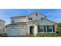 Elegant home featuring a stucco facade, gray shutters, a two-car garage, and an inviting front entrance at 18410 Blue Heron Cir, Deer Island, FL 32778