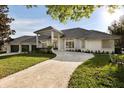 Stunning home with a three car garage, a gray tile roof, manicured lawn and a circular driveway at 2207 Cairns Ct, Orlando, FL 32835