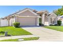 Traditional-style home features a two-car garage, well-kept lawn, and mature landscaping at 2534 Wekiva Walk Way, Apopka, FL 32703