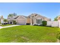 Well-maintained home with a spacious two-car garage, green lawn, and mature bushes at 2534 Wekiva Walk Way, Apopka, FL 32703
