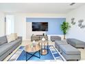 Cozy living area with a large blue rug, modern furniture, and a mounted television at 2555 Shanti Dr, Kissimmee, FL 34746