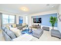 Bright living room with plush gray sofas, blue accents, and modern furnishings at 2555 Shanti Dr, Kissimmee, FL 34746