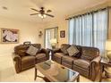 Spacious living room featuring leather sofas, decorative pillows, and ample natural light at 2706 Bushman Dr, Kissimmee, FL 34746