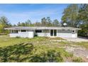 Wide view of a gray single-story home with metal roof and grassy yard at 27630 Jean Ave, Paisley, FL 32767