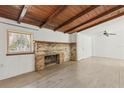 Living room features wood ceiling, fireplace, light wood flooring, and a large window at 27630 Jean Ave, Paisley, FL 32767
