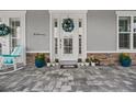 Inviting front door with decorative wreath, flanked by vibrant flowers and charming accents at 3114 Meleto Blvd, New Smyrna Beach, FL 32168