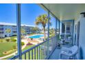 Relaxing balcony view overlooking the pool, palm trees, and the manicured gardens at 315 N Causeway # B302, New Smyrna Beach, FL 32169