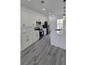 Bright kitchen boasts quartz counters, stainless appliances, a large island and stylish gray wood-look floors at 3519 Sw 131St Place St, Ocala, FL 34473