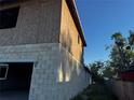Angled side view of home under construction with block and plywood walls against a sunny, blue sky at 3627 Lincoln St, Sanford, FL 32771