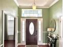 Welcoming foyer with a decorative front door, wood floors, and accent table with decor at 417 Rio Grande Ct, Kissimmee, FL 34759