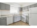 Well-lit kitchen featuring white appliances, gray cabinets, and granite countertops at 4205 S Semoran Blvd # 3, Orlando, FL 32822
