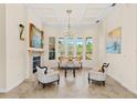 Bright and elegant living room featuring neutral colors, fireplace, decorative molding, and large windows at 6005 Bancroft Blvd, Orlando, FL 32833