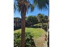 An outdoor view of the property showcases lush tropical landscaping, palm trees and building at 7900 S Orange Blossom Trl # 2052, Orlando, FL 32809