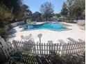 A beautiful swimming pool is surrounded by lounge chairs and a white picket fence at 7900 S Orange Blossom Trl # 2052, Orlando, FL 32809