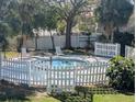 A serene pool area, fenced in and shaded by palm trees, offers a relaxing escape at 7900 S Orange Blossom Trl # 2052, Orlando, FL 32809