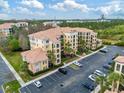 A ground-level exterior shot of a condo featuring a tile roof and ample parking at 8763 Worldquest Blvd # 5306, Orlando, FL 32821