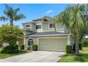 Lovely exterior featuring a two-car garage with a well-manicured lawn and verdant trees at 901 Dorset Pl, Davenport, FL 33896