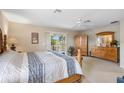 Spacious main bedroom features a ceiling fan, sliding glass doors, and wooden furniture at 901 Dorset Pl, Davenport, FL 33896