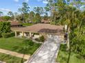 Aerial view showcasing the home's well-maintained landscaping and extended driveway in a tranquil setting at 109 Sweetwater Oaks Ln, Daytona Beach, FL 32114
