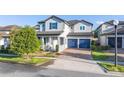 Two-story home featuring a tile roof, brick driveway, blue shutters and a two-car garage at 14602 Winter Stay Dr, Winter Garden, FL 34787