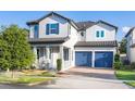 Two-story home featuring a tile roof, brick driveway, blue shutters and a two-car garage at 14602 Winter Stay Dr, Winter Garden, FL 34787