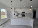 Bright, open kitchen with a large island, stainless steel appliances, and modern pendant lighting at 15462 Sw 46 Cir, Ocala, FL 34473