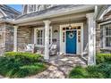 Inviting covered porch with stone accents, decorative columns, and cozy seating area with a blue front door at 1741 Pine Ave, Winter Park, FL 32789